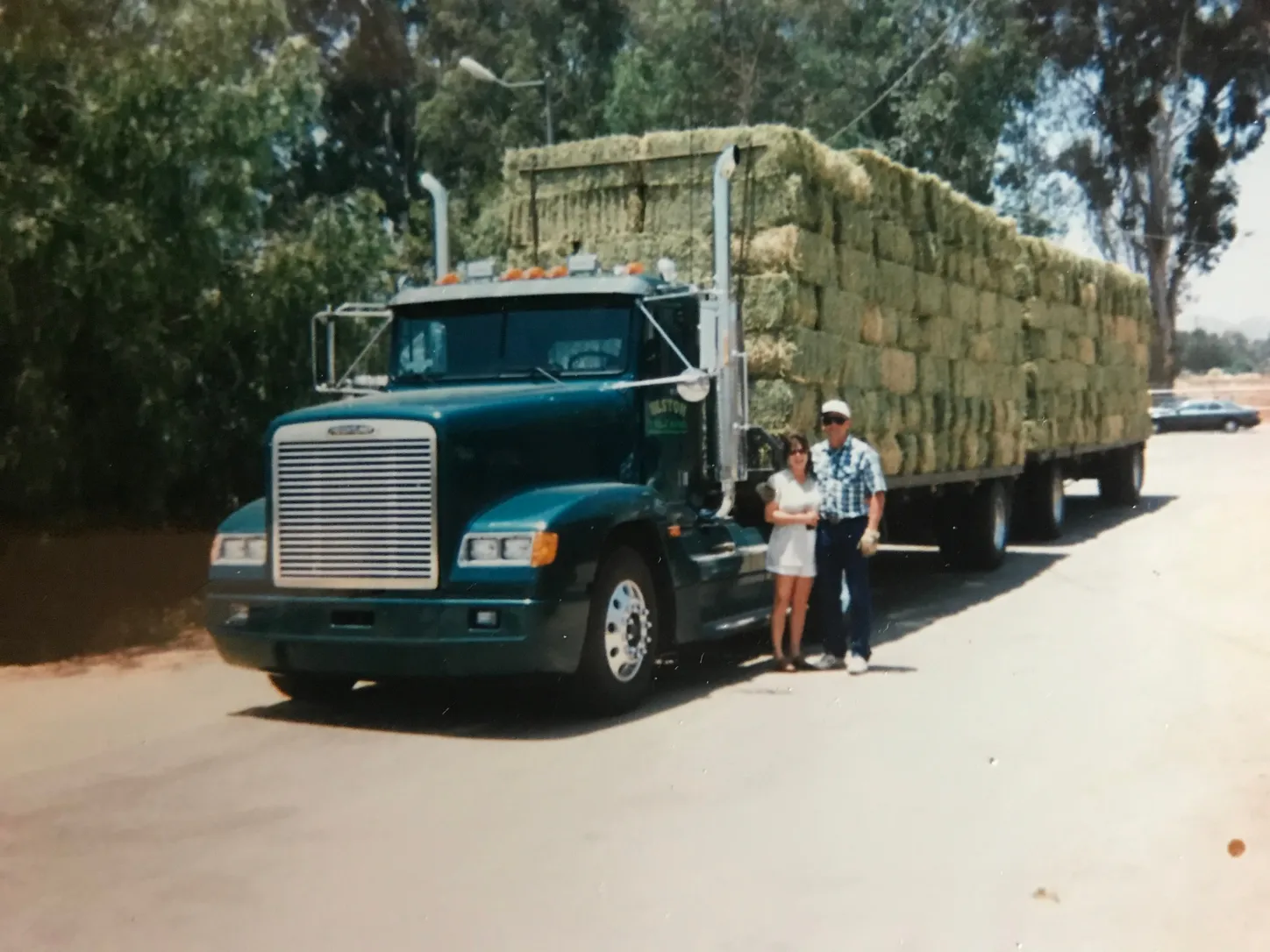 Classic vintage hay truck carrying a full load of stacked hay bales.